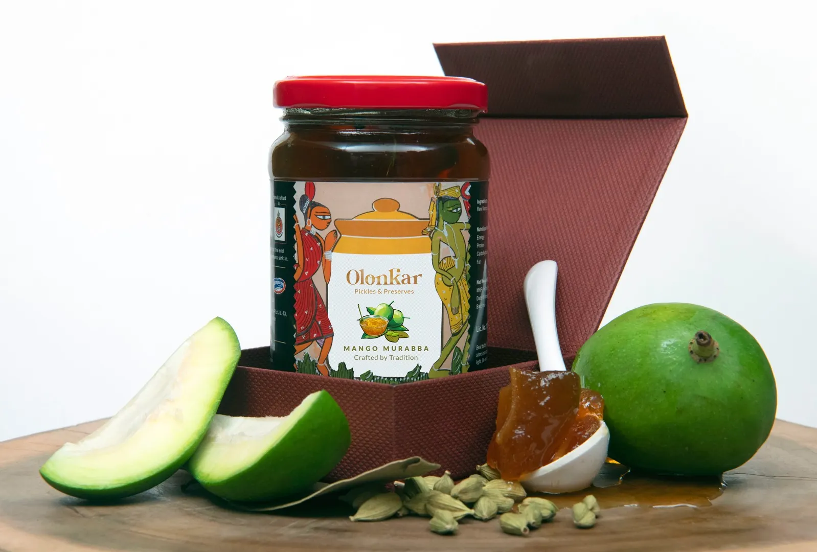 A jar of Olonkar mango murabba with raw mangoes and cardamom