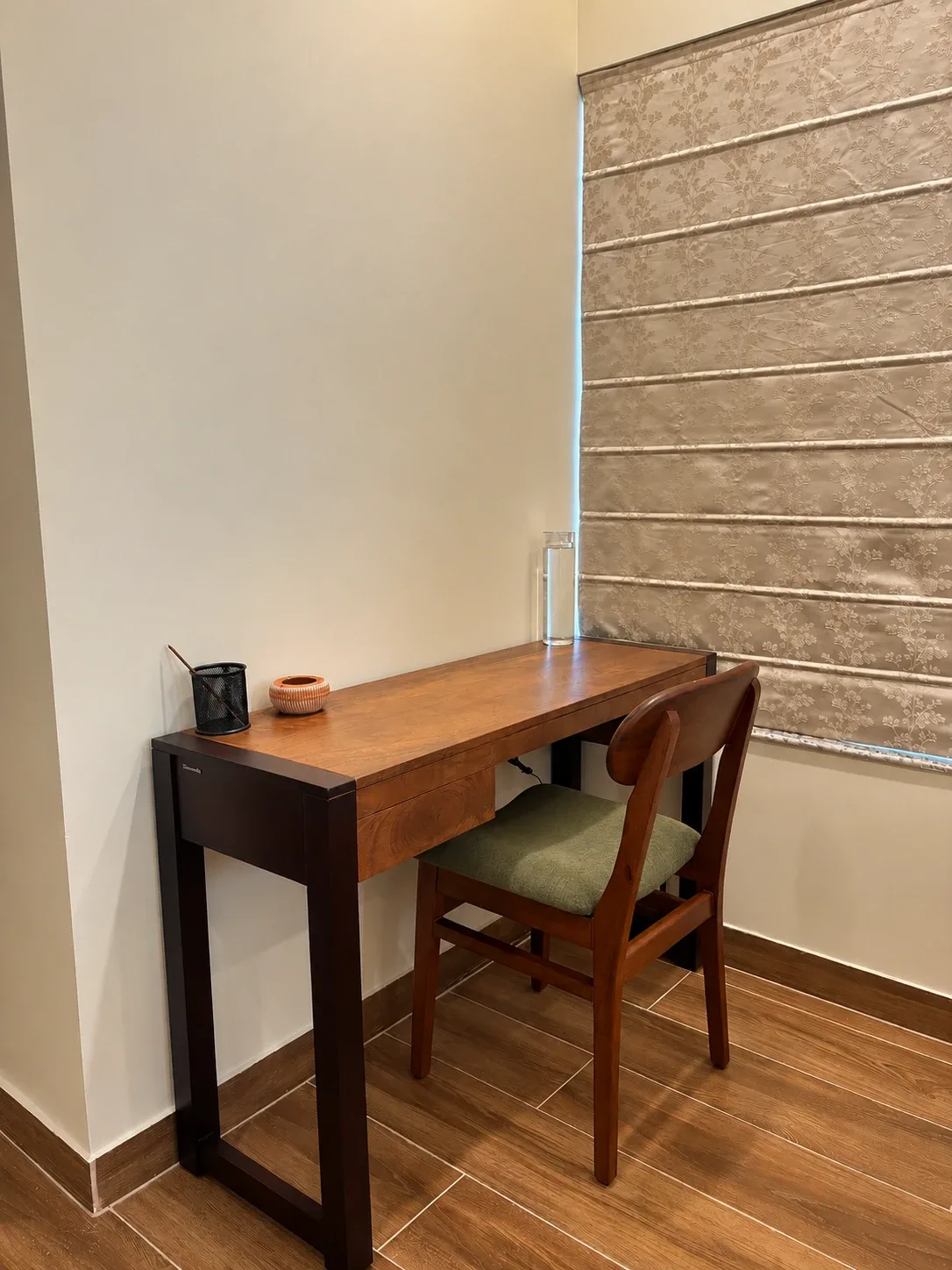 A teak writing desk and chair by a window at the Solitude Residency
